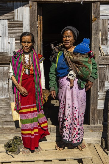 Chin women with spiderweb tattoo smoking a pipe