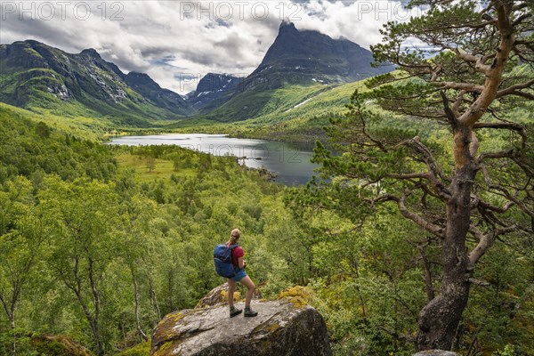 Hiker looking at high valley Innerdalen with lake Innerdalsvatna