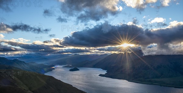 Last rays of sun shining through cloudy sky