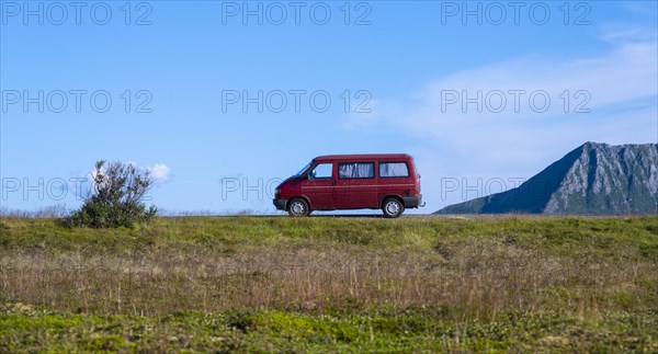 Red VW bus stands in the landscape