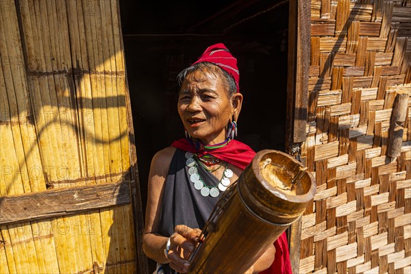 Old Kayah woman playing local instrument