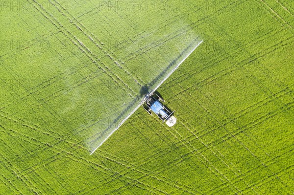 Tractor spraying fungicide onto the rice fields