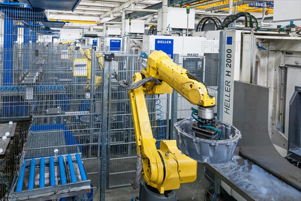 Industrial robot and car parts on a conveyor belt in a car parts factory