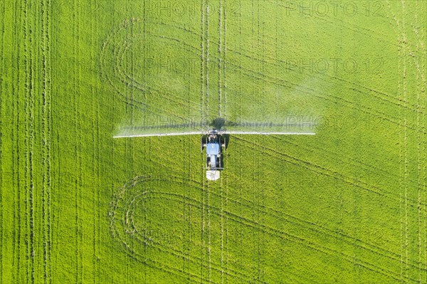 Tractor spraying fungicide onto the rice fields