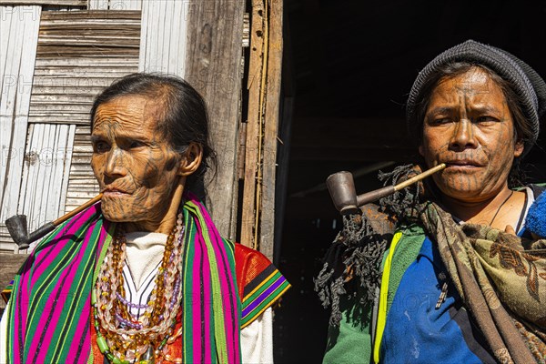 Chin women with spiderweb tattoo smoking a pipe