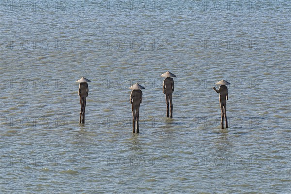 People statues standing in the ocean