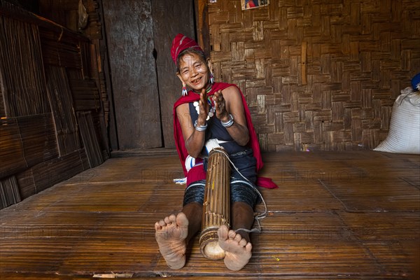 Old Kayah woman playing local instrument