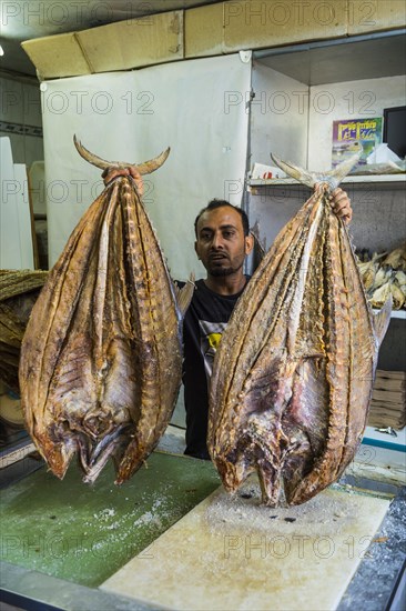 Man selling a huge dried fish