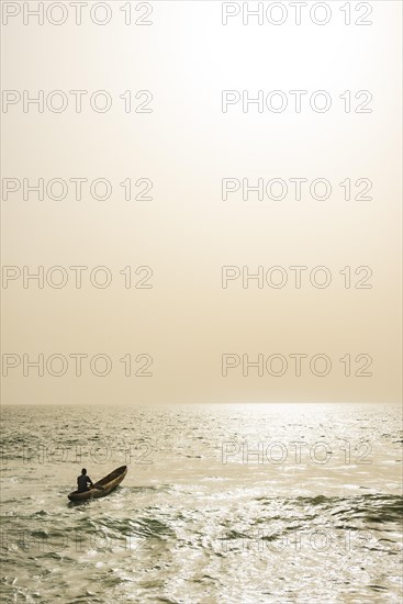 Man going out to sea in his dugout canoe