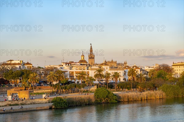 View over the river Rio Guadalquivir to the bullring Plaza de toros de la Real Maestranza de Caballeria de Sevilla and bell tower La Giralda