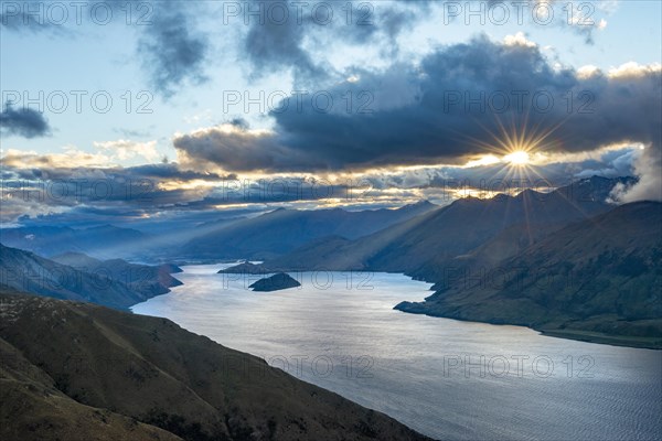 Last rays of sun shining through cloudy sky