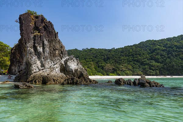 Rocky cliff on a untouched white sand beach on Smart island