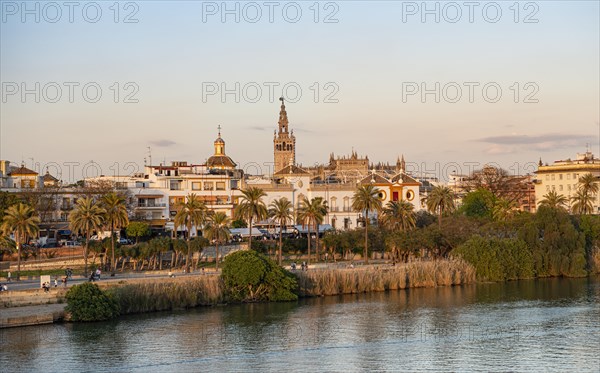 View over the river Rio Guadalquivir to the bullring Plaza de toros de la Real Maestranza de Caballeria de Sevilla and bell tower La Giralda