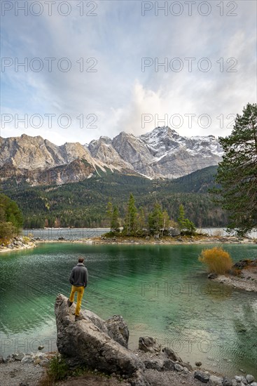 Young man standing on a rock on the shore