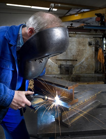 Worker in an industrial hall during oxyacetylene welding