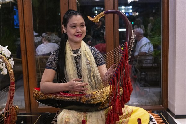 Woman playing a harp like instrument