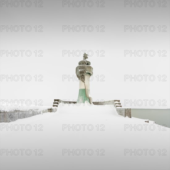 Iced quay wall and lighthouse in the harbour of Sassnitz on the island of Ruegen