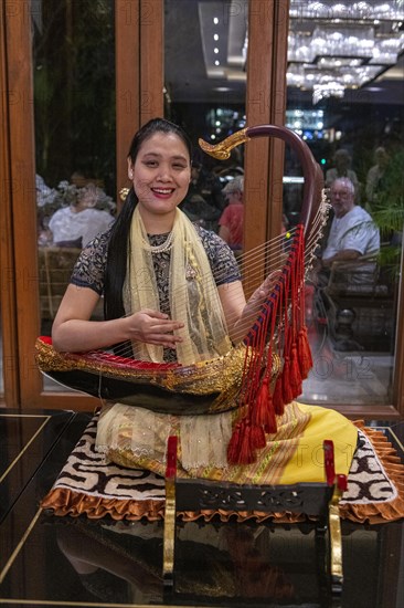 Woman playing a harp like instrument