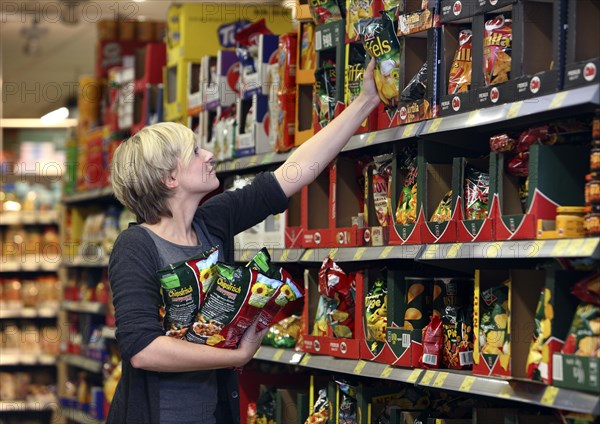 Female customer buying crisps, food hall, supermarket, Germany