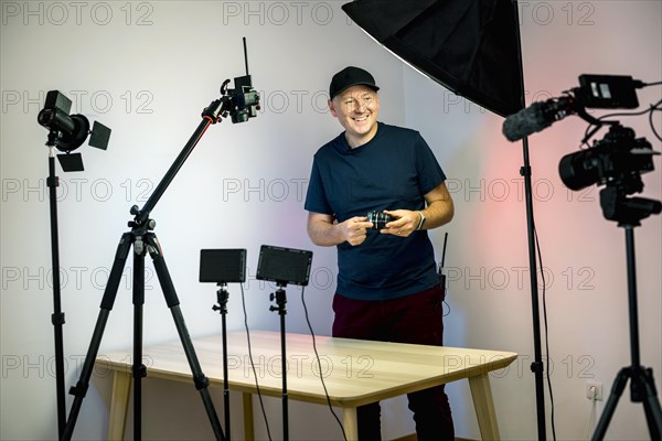 An influencer with a lens creating and recording content in his studio