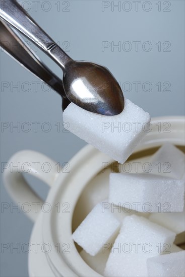 Sugar tongs holding sugar cubes