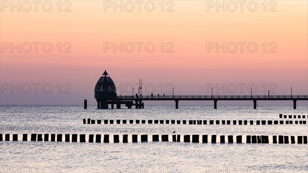 Groyne and diving bell with pier at the beach of Zingst at sunrise
