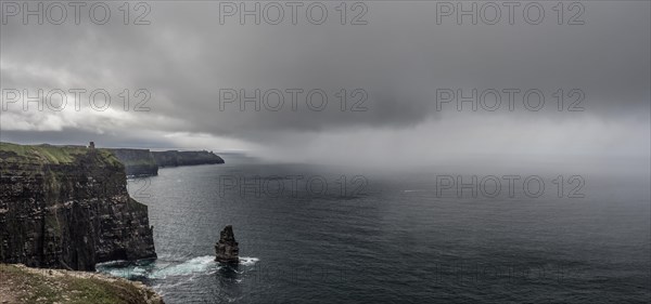 Thunderclouds and rain showers over cliff and Atlantic Ocean