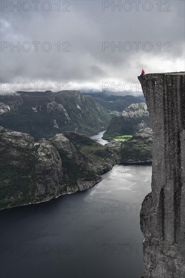 Person sitting on steep cliff