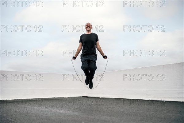 A man exercising on the rooftop using a jumping rope during lockdown
