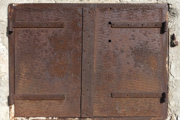 Rusty iron hatch on a house