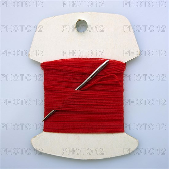 Red sewing thread and needle