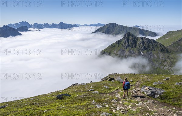 Hiker looking over mountain landscape in clouds