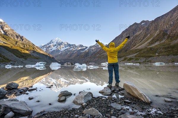 Hiker at the lake stretching her arms in the air