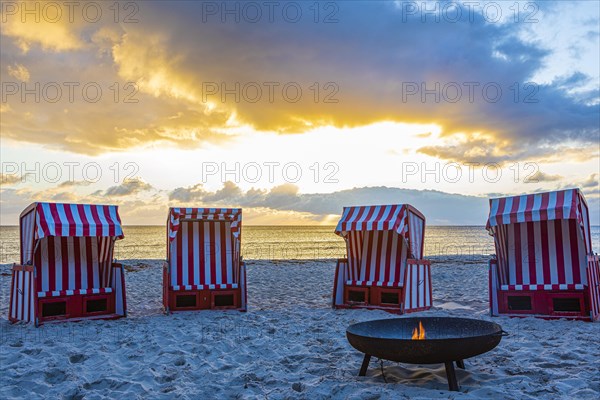 Beach chairs and fire bowl at sunrise at the big beach of Thiessow