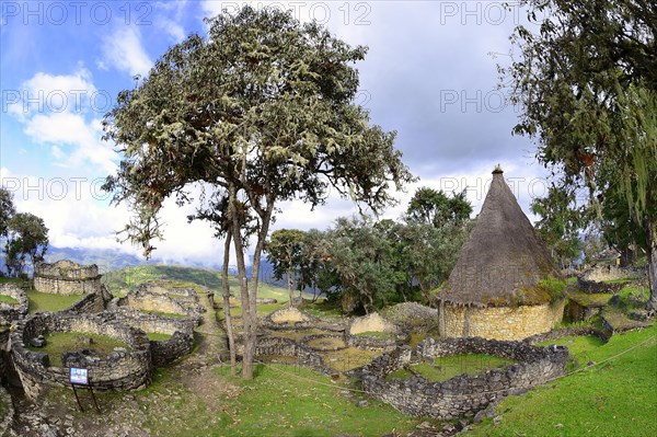 Round foundation walls and reconstructed hut in the ruined city of the Chachapoya culture