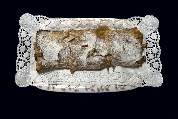 Freshly baked apple strudel on a plate with cake paper