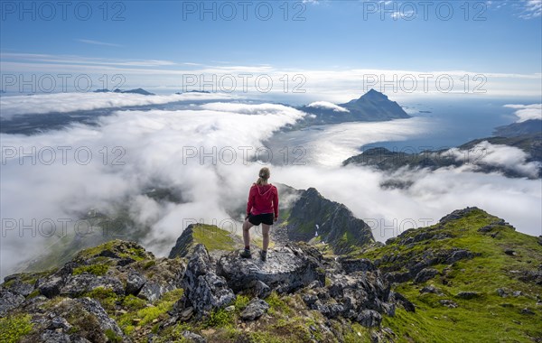 Hiker looking over mountain landscape in clouds
