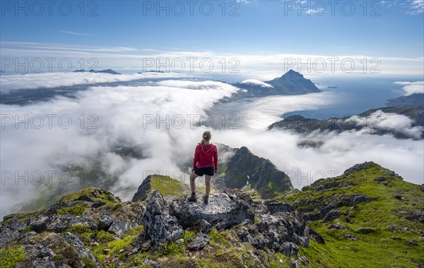 Hiker looking over mountain landscape in clouds