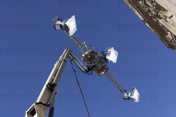 Three spotlights in front of a blue sky