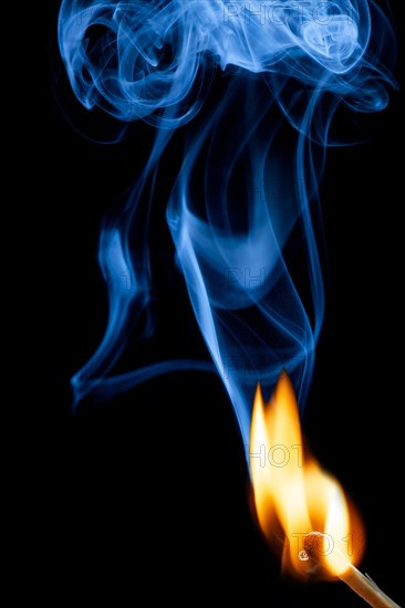 Burning match with blue smoke