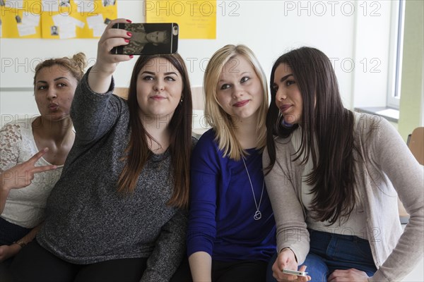 Vocational school students with their smartphones during break at the Elly-Heuss-Knapp-Schule