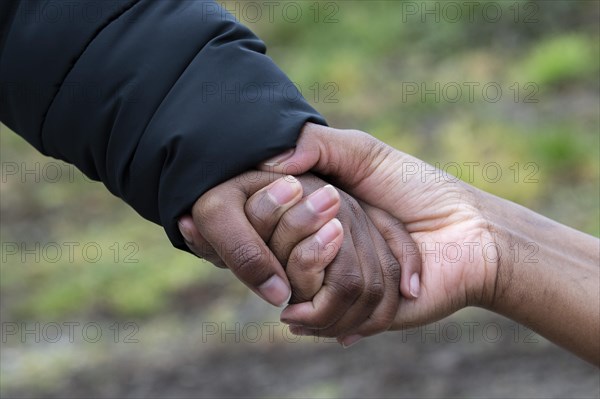 A Somali woman who fled to Germany holds the hand of her eight-year-old son