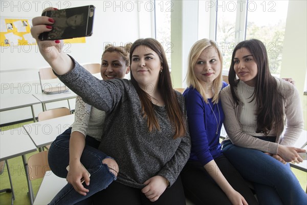 Vocational school students with their smartphones during break at the Elly-Heuss-Knapp-Schule