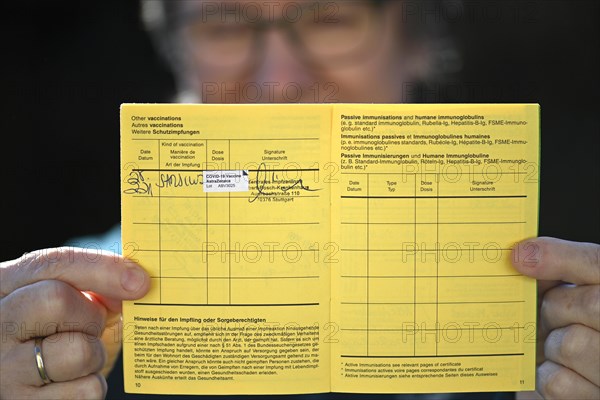 Woman proudly showing her vaccination certificate after being vaccinated with AstraZeneca against Covid-19