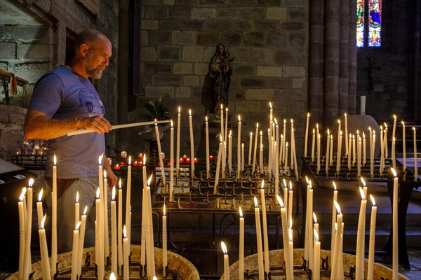 Man lighting a votive candle