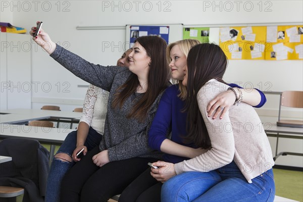 Vocational school students with their smartphones during break at the Elly-Heuss-Knapp-Schule