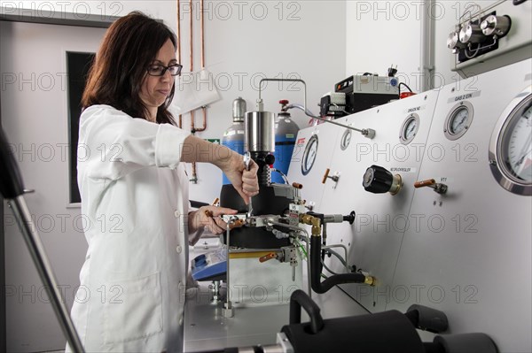 Scientist at the high-pressure machine for simulating conditions deep in the earth for research on the origin of life