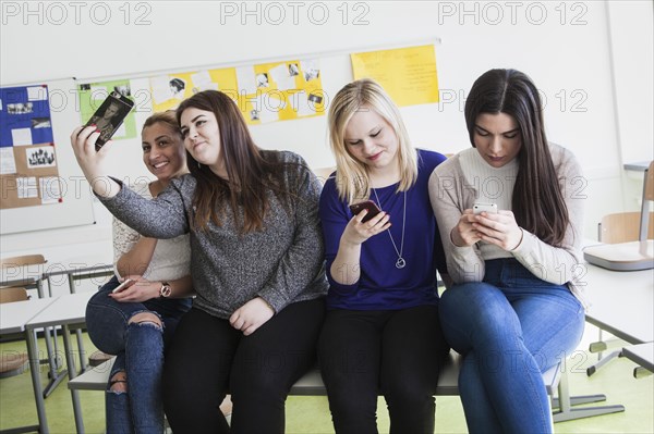 Vocational school students with their smartphones during break at the Elly-Heuss-Knapp-Schule