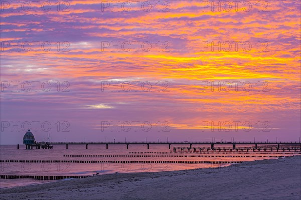 Groyne and diving gondola with pier at the beach of Zingst at sunrise