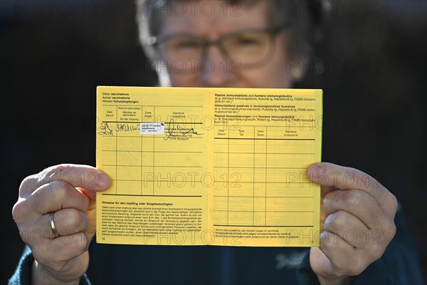 Woman proudly showing her vaccination certificate after being vaccinated with AstraZeneca against Covid-19